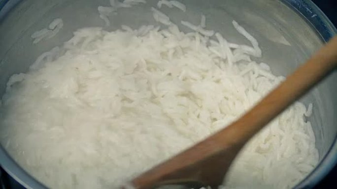 煮沸的米饭在锅中搅拌