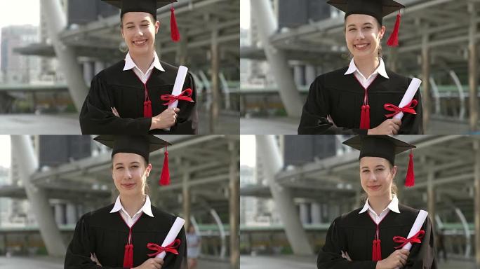 穿着学术服装的成功毕业生拿着文凭，对着镜头微笑。
