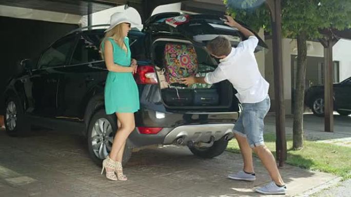 镜头耀斑: 年轻的丈夫用SUV塞满所有行李后，兴奋的妻子鼓掌。