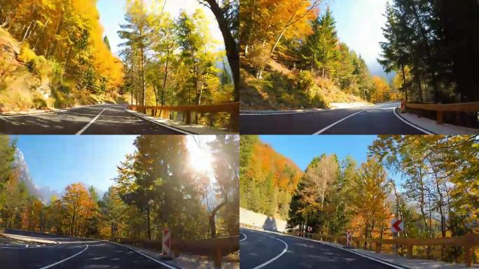 在蜿蜒的山路上行驶穿过秋天的森林