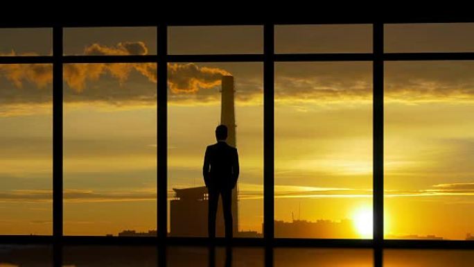 站在工业城市背景窗户附近的男人
