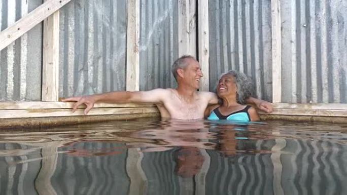 享受热水游泳池的高级成年夫妇