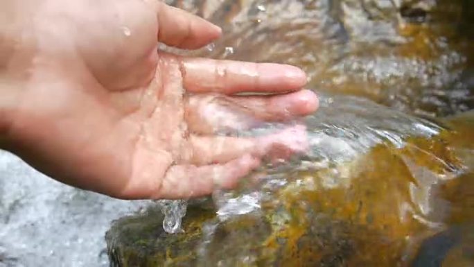 手在干净的溪流中抽水