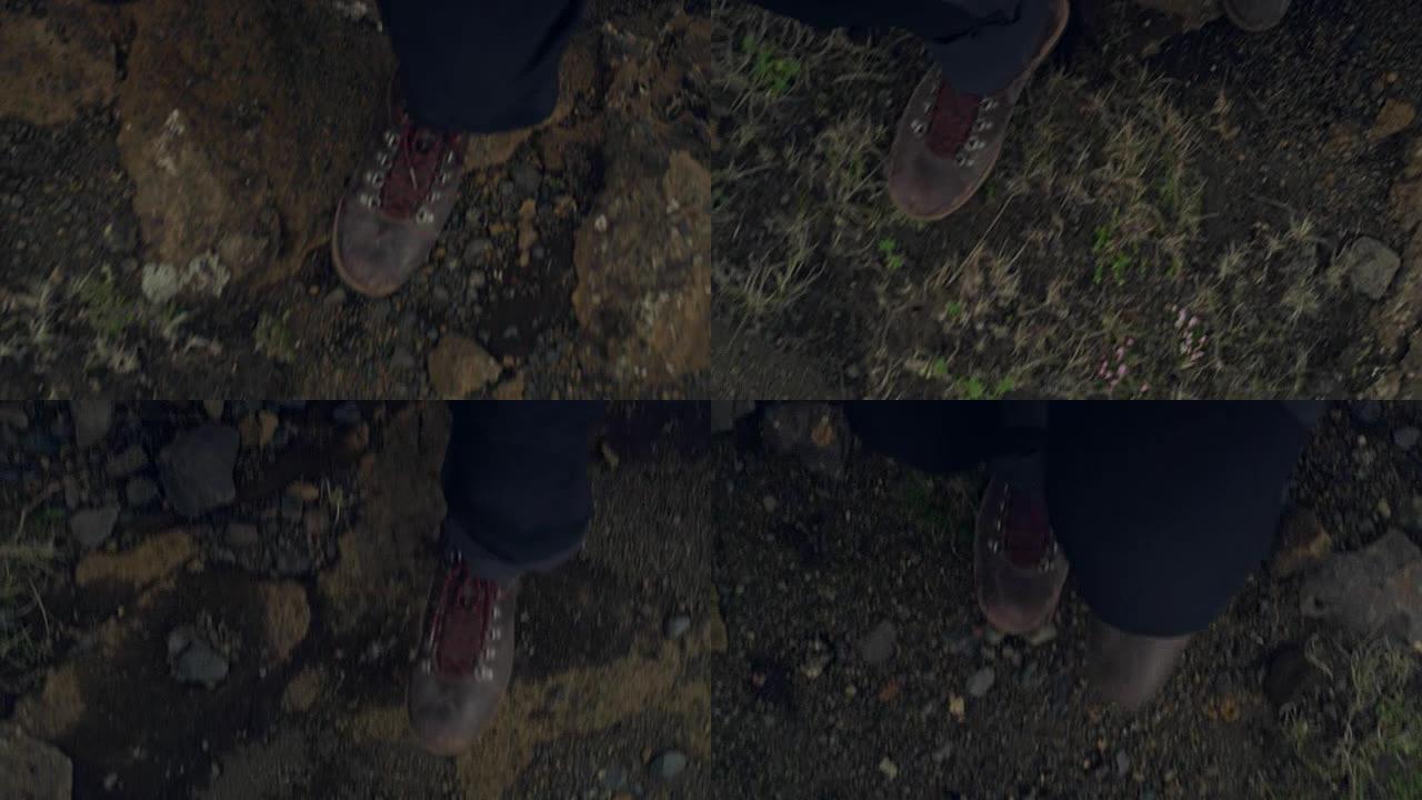 在火山土壤上行走。鞋子上的特写