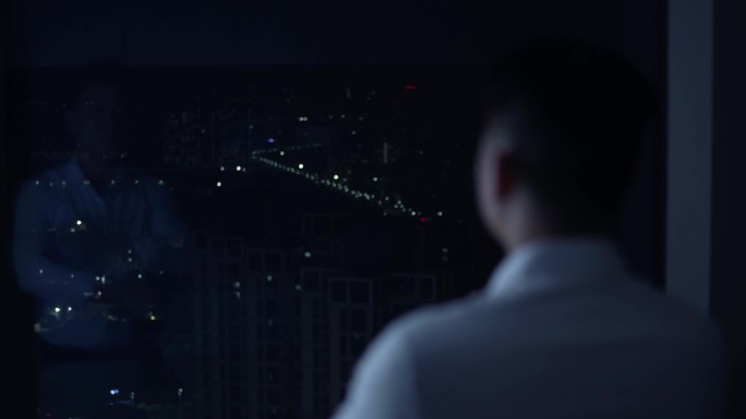 成功人士站在窗边背影城市夜景思考压力大