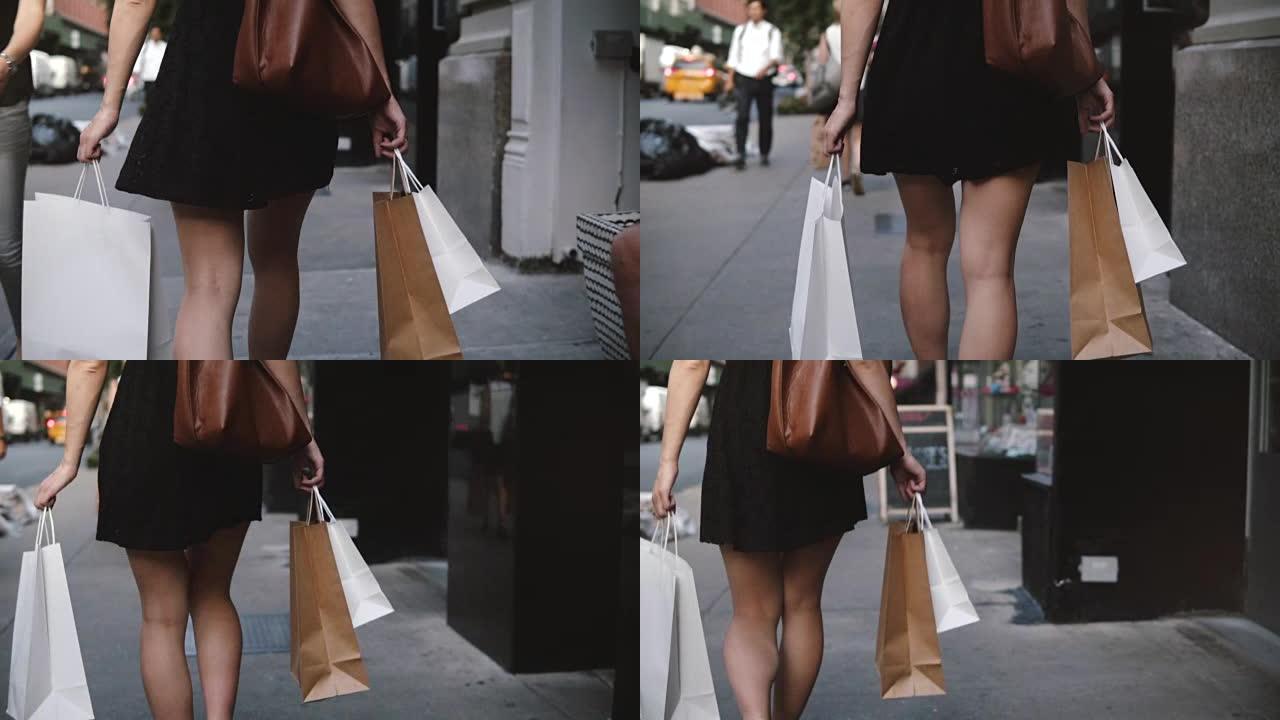 年轻的女性时尚博主双手背着购物袋在街上慢动作