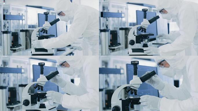 在实验室中，穿着防护服的科学家进行研究使用显微镜和个人计算机。生产半导体和药品的现代工厂。
