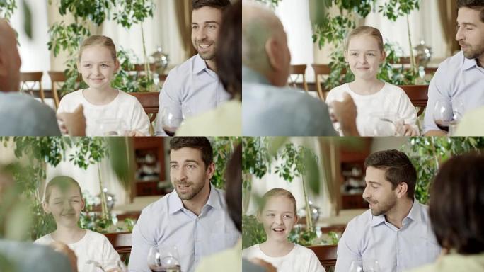与父亲，祖母和祖父在餐厅的小女孩