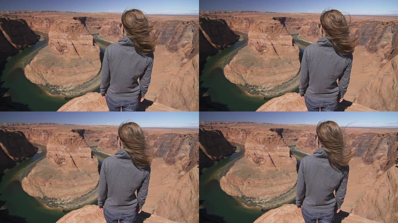 一个女人站在大峡谷的边缘，置身其中