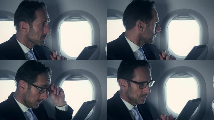 飞机上的商人关注业务的男人飞机上工作