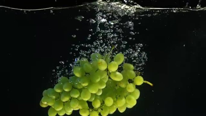 新鲜葡萄慢慢落入水中，健康零食，维生素来源。