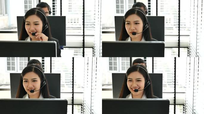 使用电脑佩戴耳机的女商人