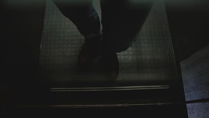 穿着棕色鞋子的欧洲年轻人骑着电梯走了出来，透过透明的玻璃墙看到了，高角度的景色