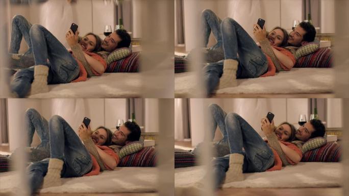 情侣在地毯上用智能手机看照片