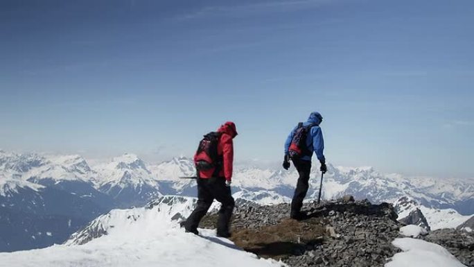 登山者到达白雪覆盖的山峰