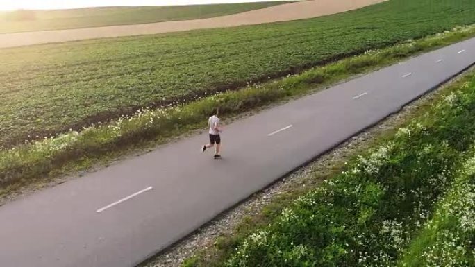 在路上奔跑的运动员。四轴飞行器射击