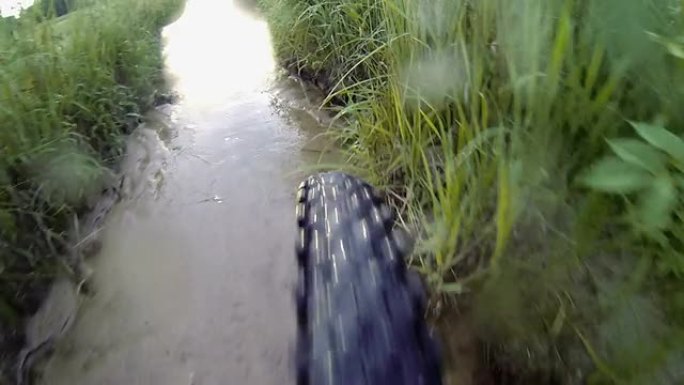 骑着山地自行车穿过潮湿泥泞的小路。