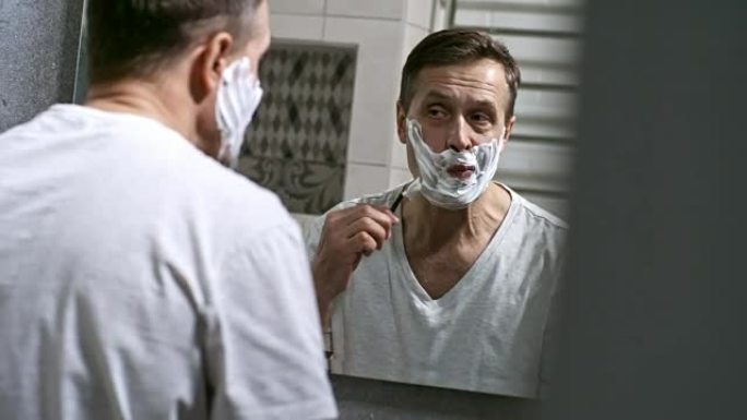 男人在浴室刮胡子时使用剃刀
