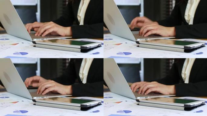使用数字平板电脑和图表文档在笔记本电脑上工作的女商人