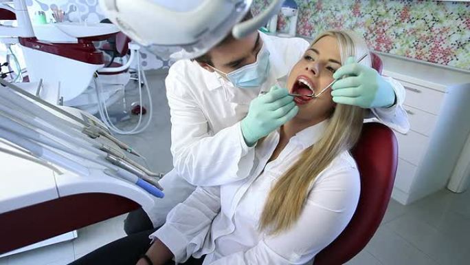 男牙医正在检查一位女病人。