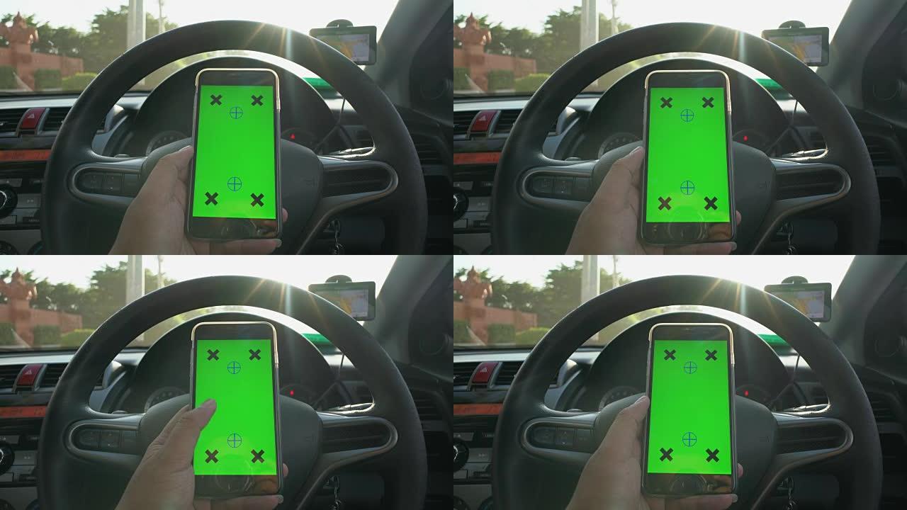 商人在带有阳光，绿屏的汽车中使用智能手机的特写镜头