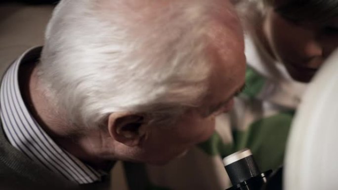 爷爷和孙子带着望远镜