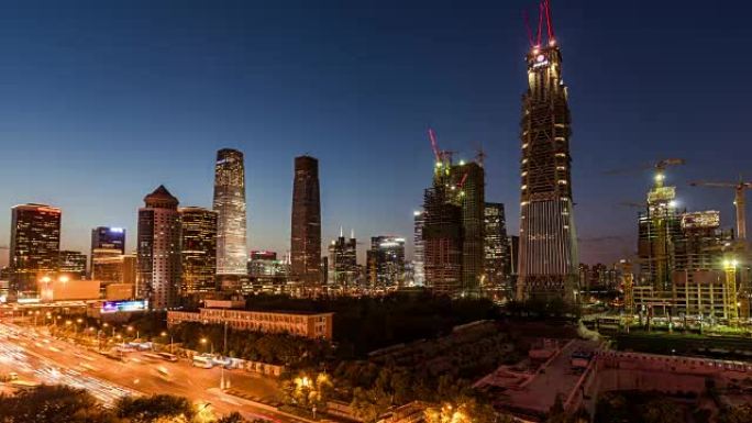 T/L WS LA RL PAN照明摩天大楼和带起重机的大型建筑工地，黄昏到夜晚的过渡/中国北京