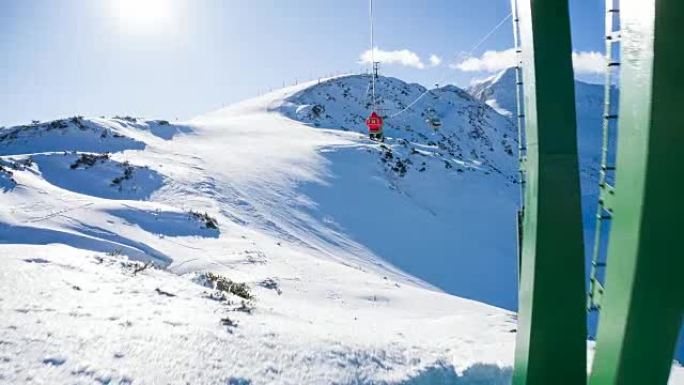 晴天在滑雪胜地乘坐升降椅时欣赏山景