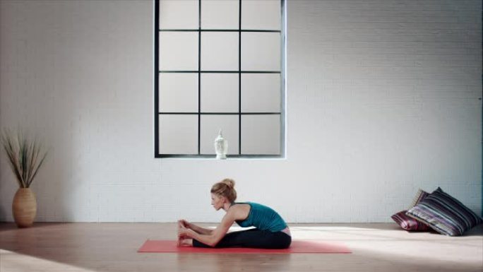 女人在健身房练习瑜伽 (前弯)
