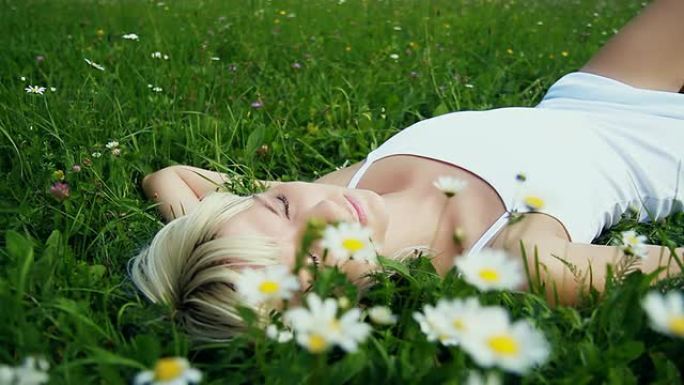 一个年轻女人睡在新鲜的绿草里