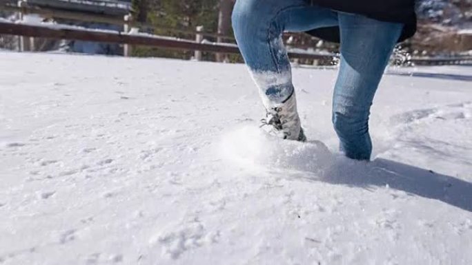 年轻女子在新鲜的积雪中膝盖深处奔跑