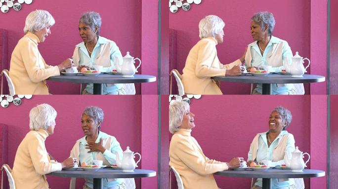 两名多种族的高级妇女在咖啡店里交谈
