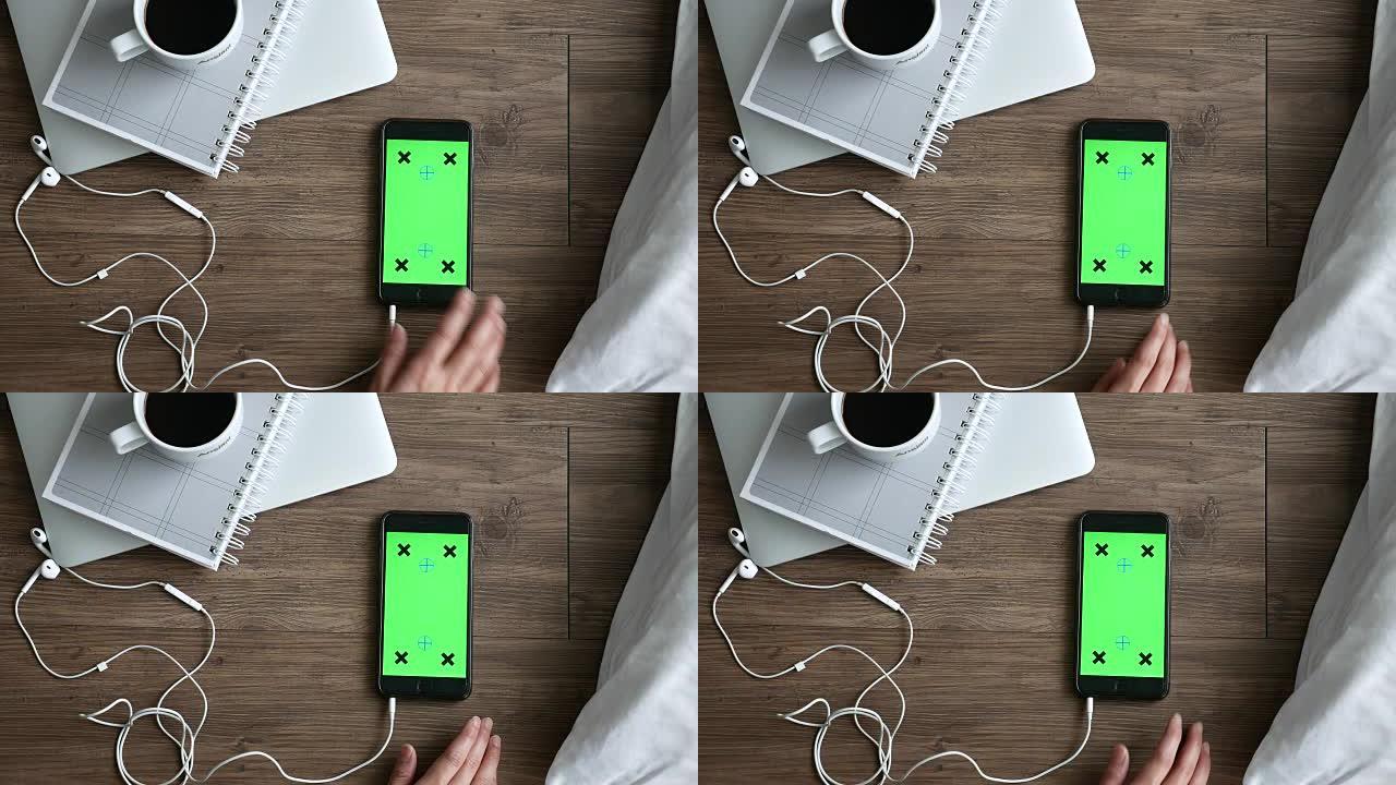 带耳机的智能手机绿屏，顶视图