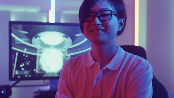 赢得在线比赛后，英俊的东亚职业玩家在电子游戏中转身微笑。时尚霓虹复古拱廊房。