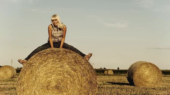 高清：可爱的女人坐在干草捆上
