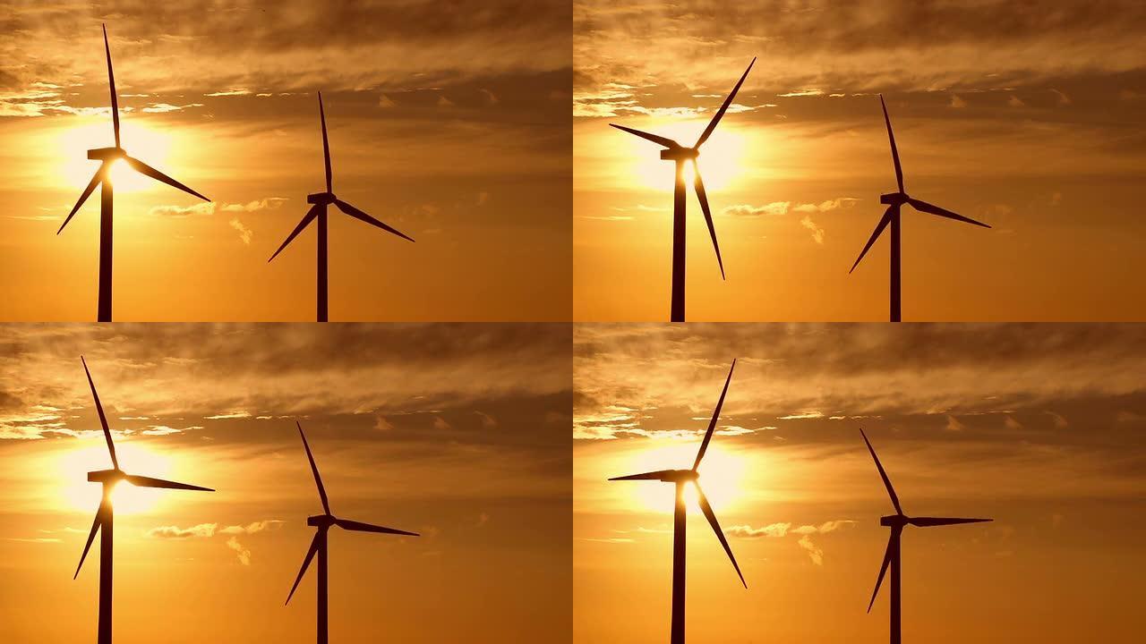 两个风力涡轮机在日出时转动