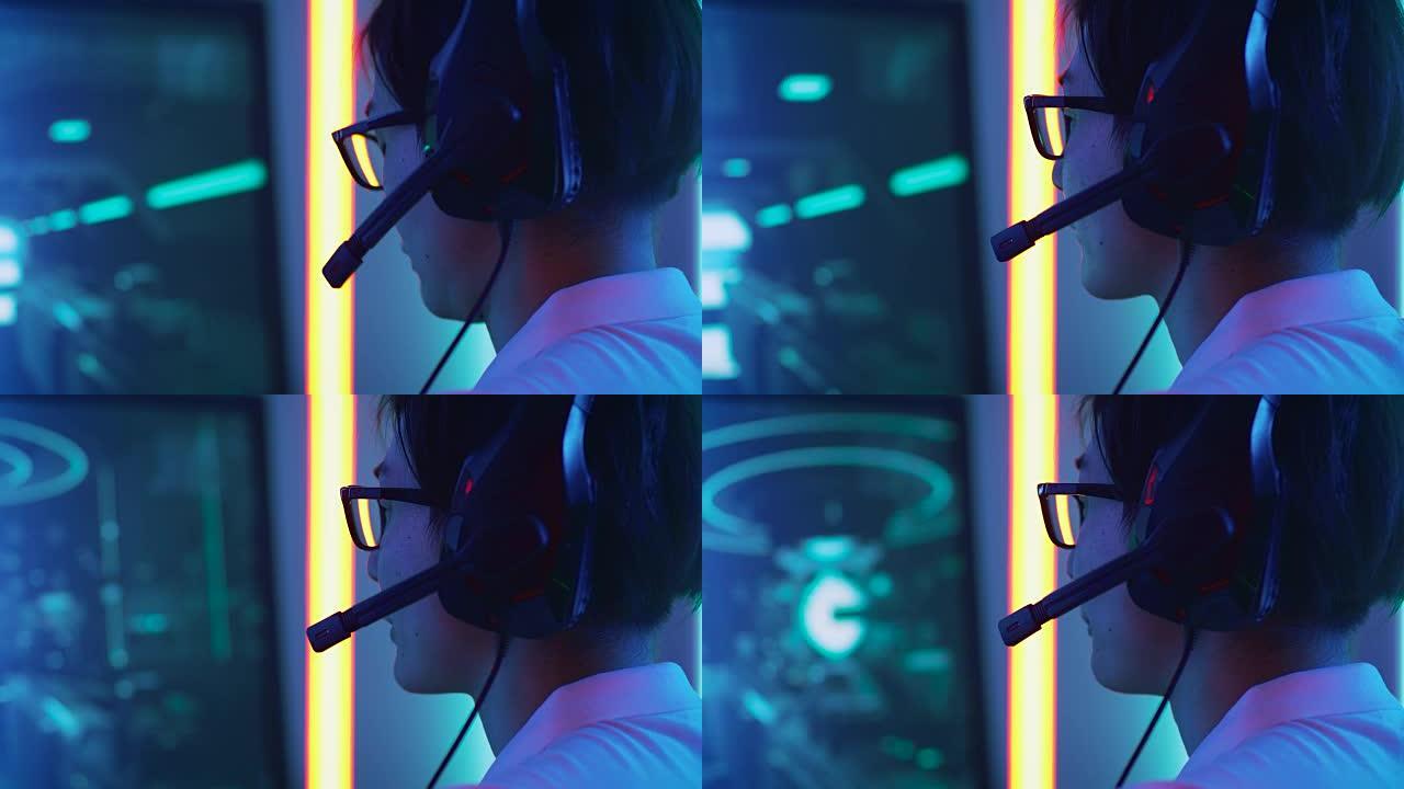 专业东亚玩家在他的个人电脑上玩在线视频游戏的特写肖像照片。对着麦克风说话。复古拱廊风格的霓虹灯点亮的