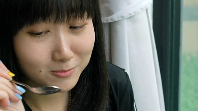 迷人的年轻亚洲女人喜欢吃草莓冰淇淋