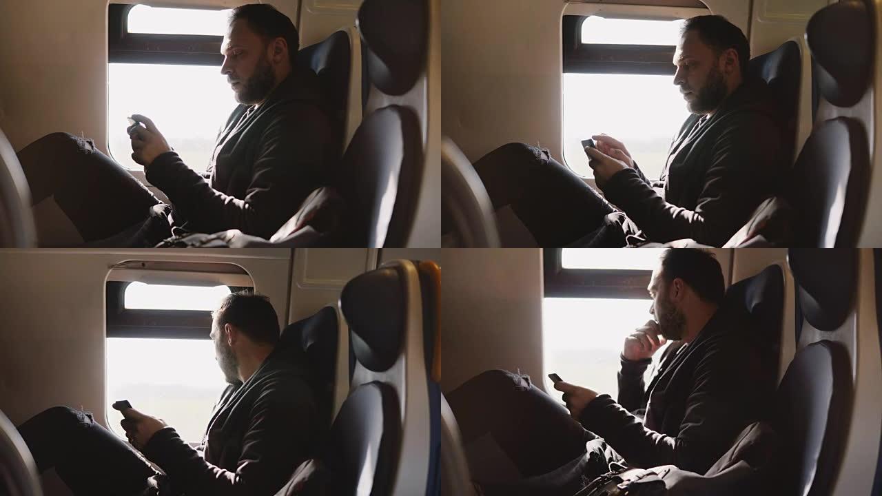 自信成功的高加索商人在火车靠窗的座位上旅行时使用智能手机移动办公应用程序
