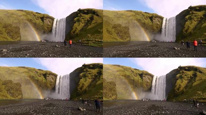 游客在冰岛欣赏Skogafoss瀑布的景色