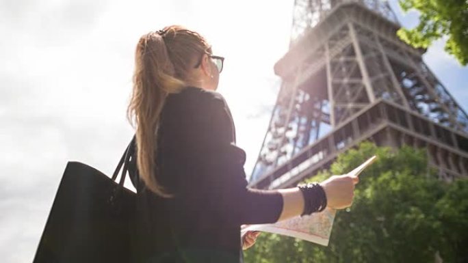 在阳光明媚的日子里，女人在巴黎的街道上漫步时欣赏埃菲尔铁塔