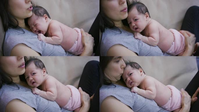 刚出生的婴儿在母亲抱着她时打哈欠