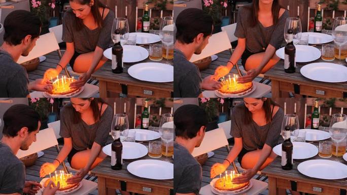 保护屋顶蛋糕上燃烧蜡烛的朋友