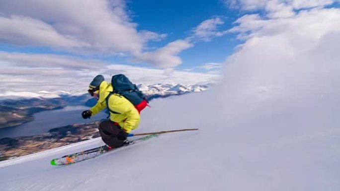 自由式滑雪者滑雪粉雪，背景为峡湾