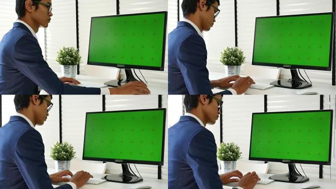商人在办公室使用带有绿屏的计算机