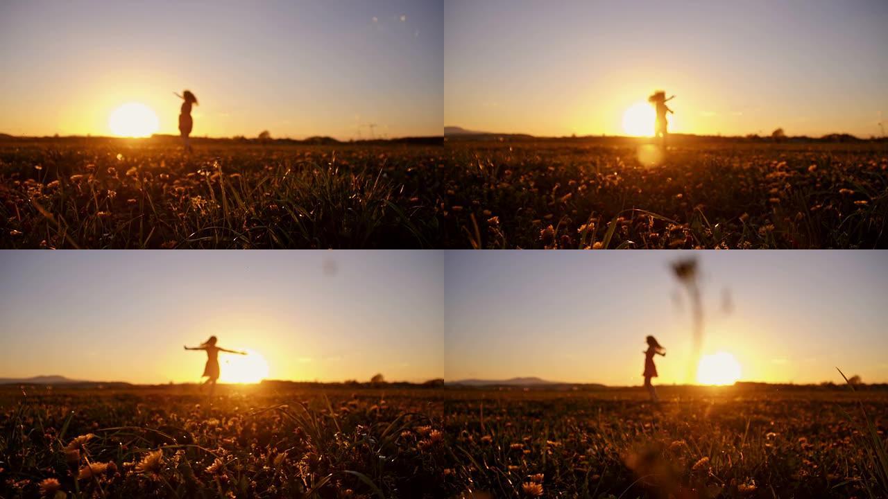 SLO MO快乐的女孩在日落时在草地上旋转