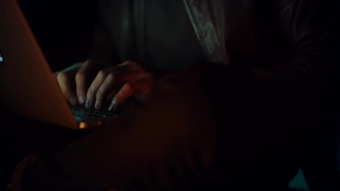 男人拿着笔记本电脑坐在篝火旁