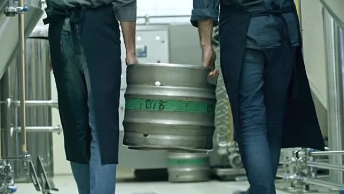 同事在啤酒厂漫步时一起拿着啤酒桶