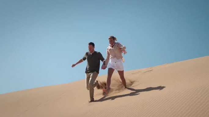 沙漠中的情侣旅行旅游牵手奔跑度假休闲