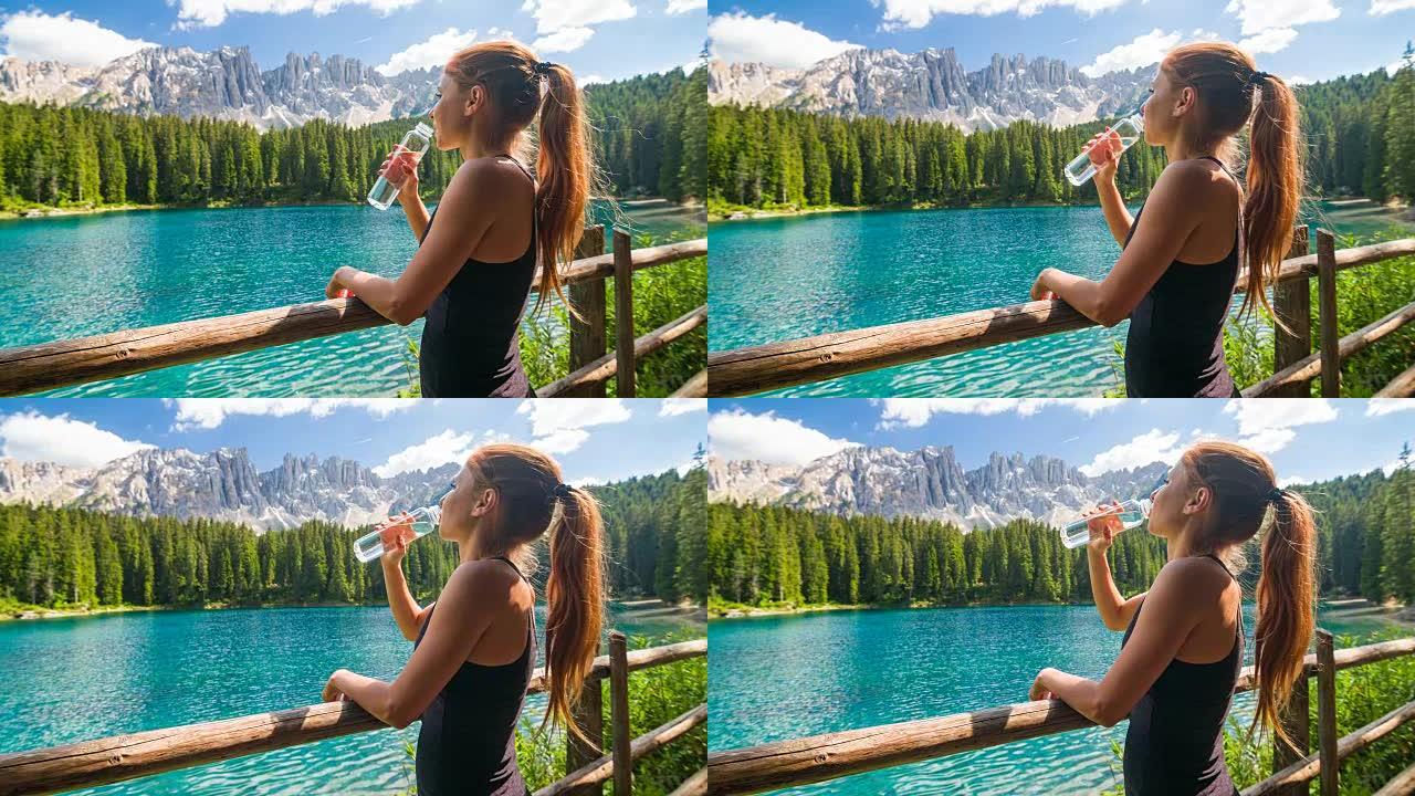多洛米蒂山脉拉戈迪卡雷扎山的快乐女游客享受着令人惊叹的景色，饮用水